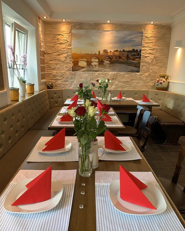 Festlich gedeckte Tafel mit roten Servietten und Rosen